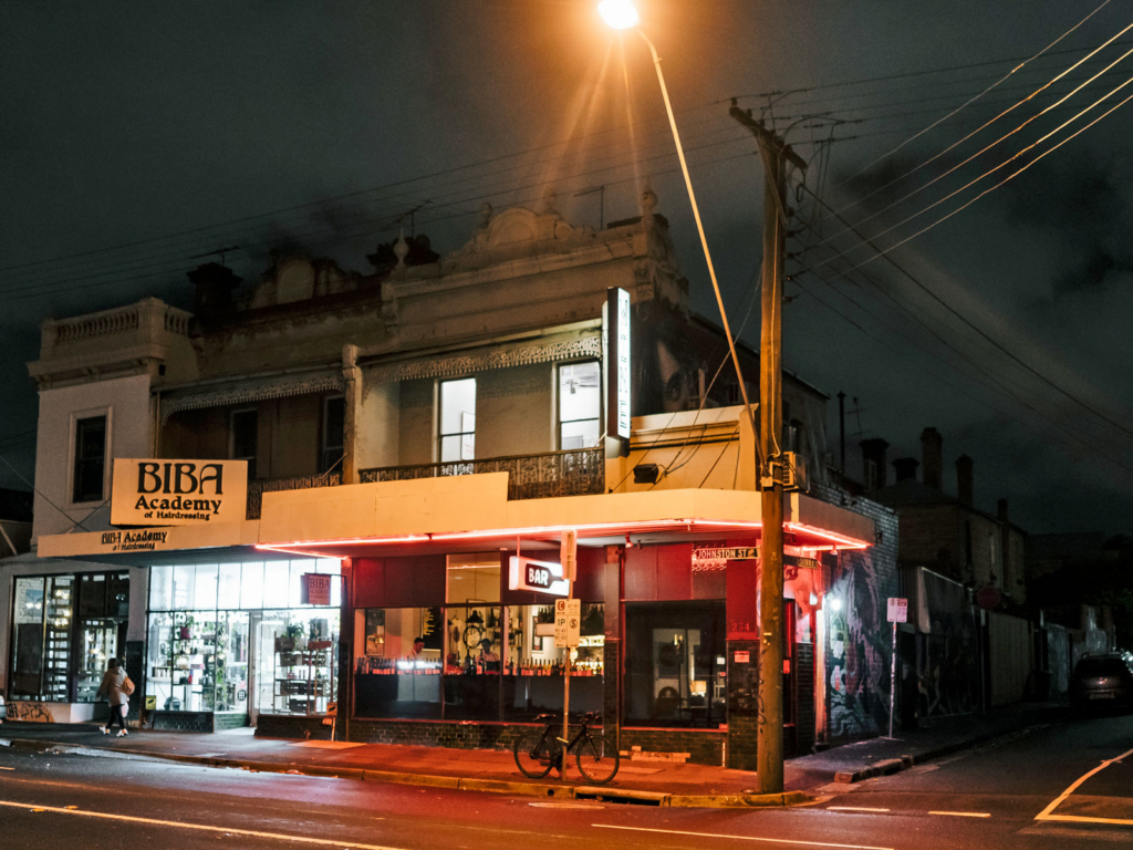 A photo of Johnson Street at night, showing a bar and a street corner under an amber streetlight.